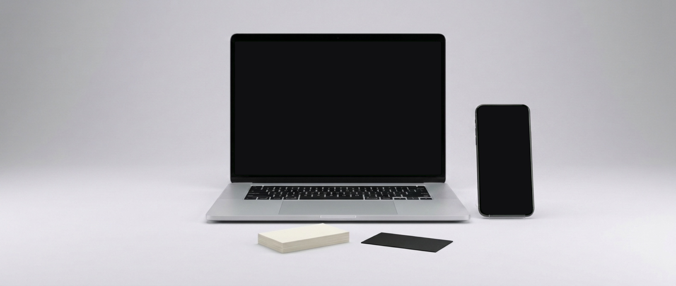 Your new website on a laptop and your business inbox on a phone, with your business cards